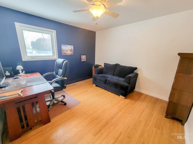 office area with a ceiling fan, light wood-style flooring, and baseboards