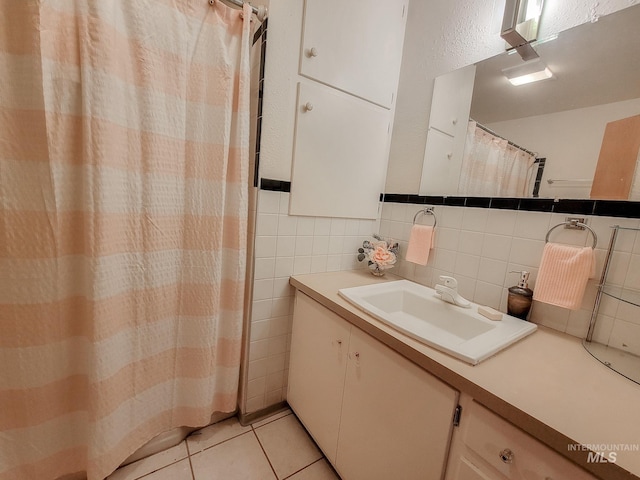 full bathroom with tile patterned flooring, tile walls, and vanity