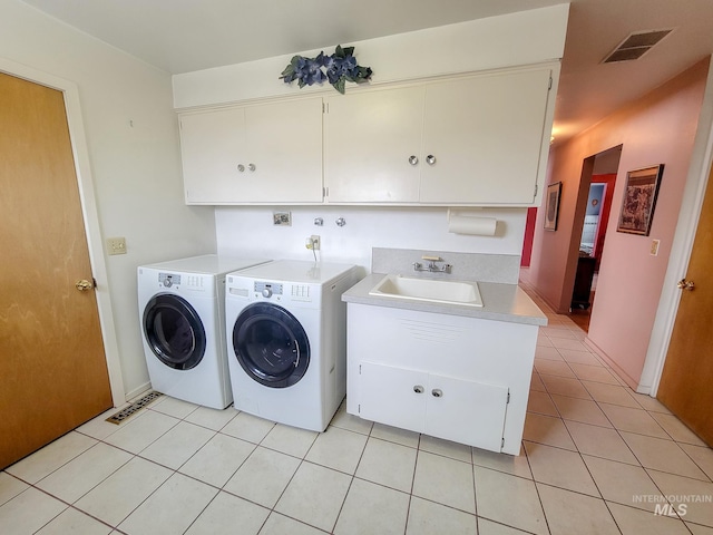 laundry room with light tile patterned floors, cabinet space, a sink, and separate washer and dryer