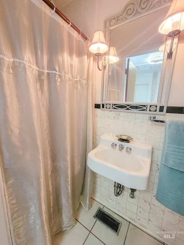 full bath featuring visible vents, backsplash, tile patterned floors, a sink, and tile walls