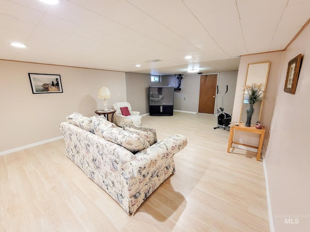 living area with light wood finished floors, recessed lighting, visible vents, and baseboards