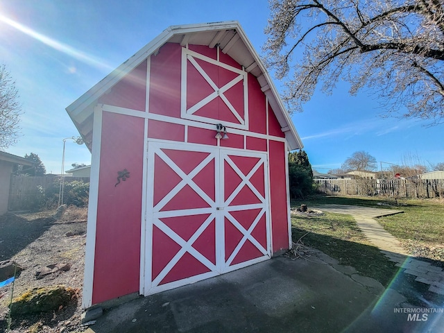 view of barn featuring fence