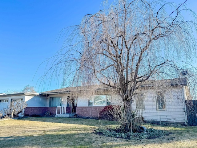 single story home with brick siding and a front lawn