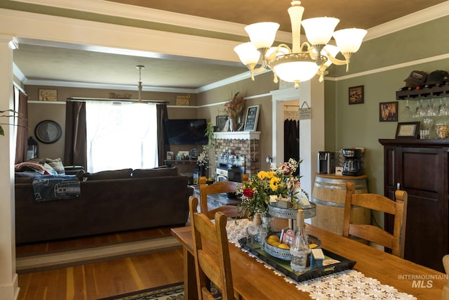 10489 Scotch Pine Rd, Payette, ID 83661 - dining room featuring a chandelier, wood finished floors, crown molding, and a fireplace