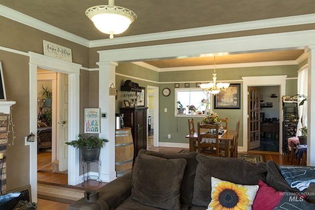10489 Scotch Pine Rd, Payette, ID 83661 - living room featuring a chandelier, decorative columns, wood finished floors, and ornamental molding