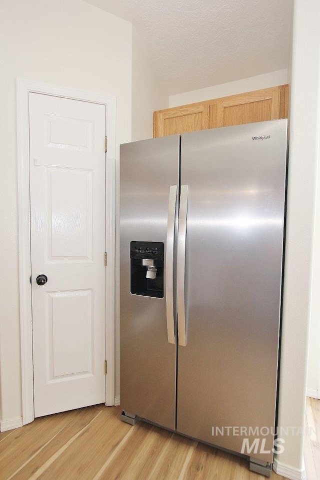 kitchen with light wood-style flooring, light brown cabinetry, and stainless steel fridge with ice dispenser