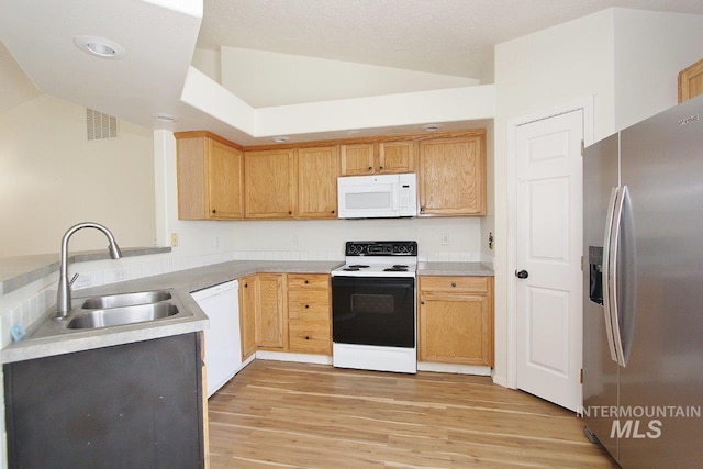kitchen with a sink, white appliances, light wood finished floors, light countertops, and visible vents
