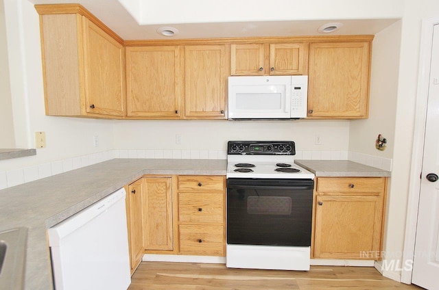 kitchen with light countertops, light brown cabinetry, light wood finished floors, and white appliances