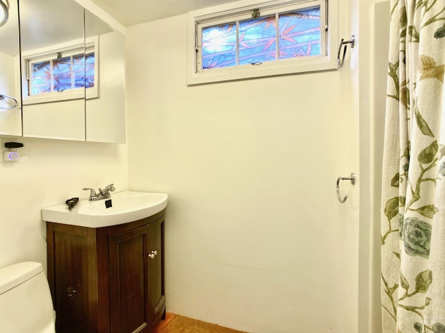 bathroom with toilet, curtained shower, and vanity