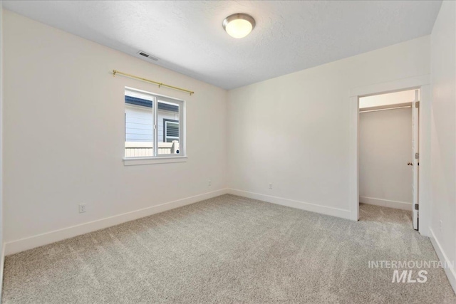2967 E Diorite St, Nampa, ID 83686 - unfurnished bedroom with carpet, baseboards, a walk in closet, a closet, and a textured ceiling