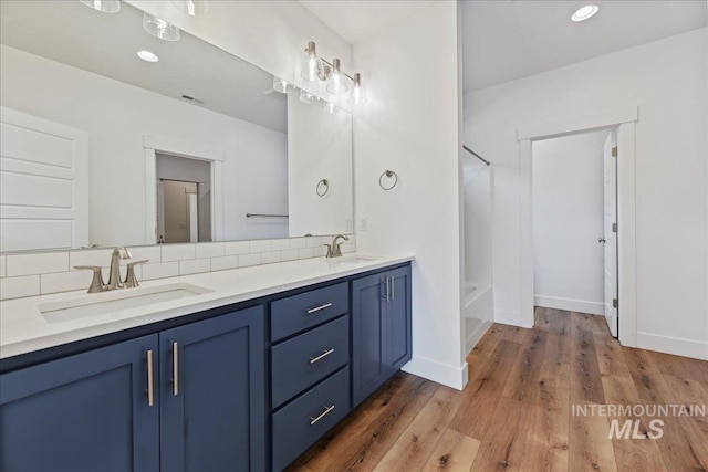2967 E Diorite St, Nampa, ID 83686 - full bathroom with double vanity, backsplash, wood finished floors, shower / bathtub combination, and baseboards
