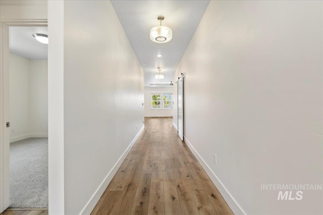 2967 E Diorite St, Nampa, ID 83686 - hallway featuring baseboards, light wood-style flooring, and a barn door