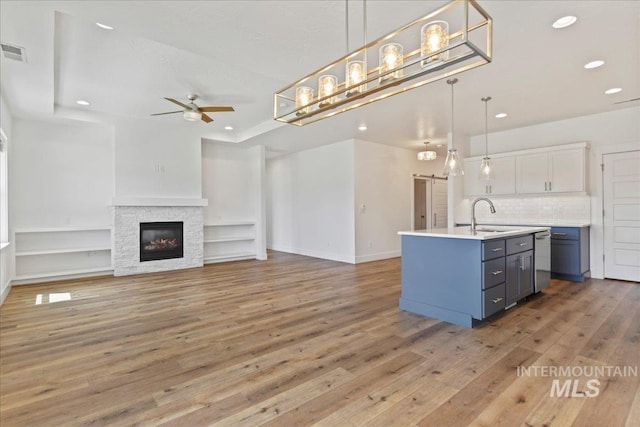 2967 E Diorite St, Nampa, ID 83686 - kitchen featuring a barn door, a ceiling fan, decorative backsplash, light wood-style floors, and recessed lighting