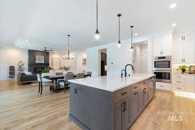 124 S Eagles Roost Way, Eagle, ID 83616 - kitchen featuring double oven, light wood-style flooring, white cabinetry, open floor plan, and recessed lighting