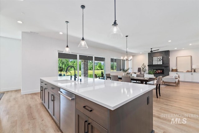124 S Eagles Roost Way, Eagle, ID 83616 - kitchen with stainless steel dishwasher, a fireplace, recessed lighting, open floor plan, and light wood-type flooring