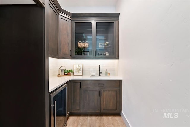 124 S Eagles Roost Way, Eagle, ID 83616 - indoor wet bar featuring beverage cooler, backsplash, light wood-type flooring, and freestanding refrigerator