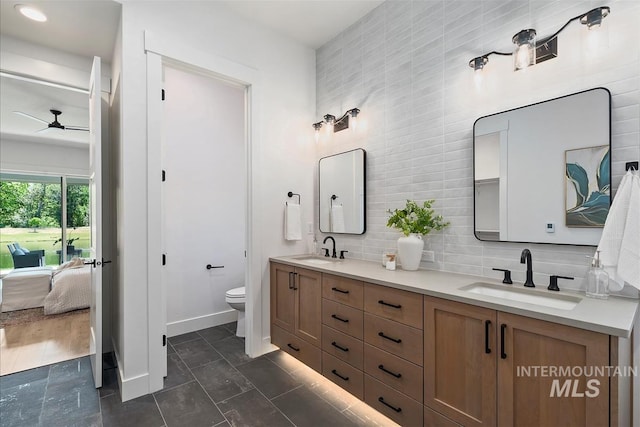 124 S Eagles Roost Way, Eagle, ID 83616 - ensuite bathroom featuring ceiling fan, double vanity, backsplash, and tile walls