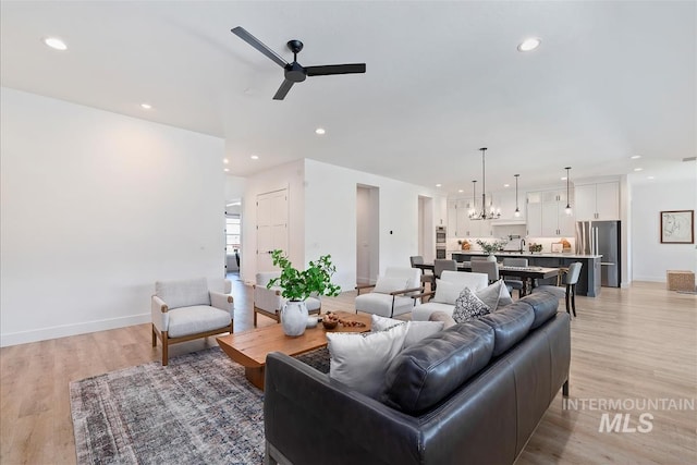 124 S Eagles Roost Way, Eagle, ID 83616 - living room featuring ceiling fan, light wood-style floors, recessed lighting, and a chandelier