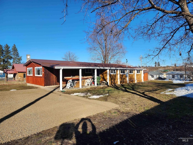 view of front of house with driveway and a chimney