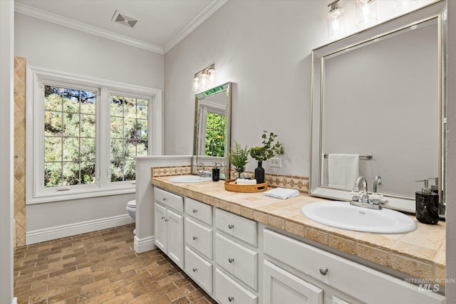 bathroom with brick flooring, toilet, plenty of natural light, ornamental molding, and baseboards