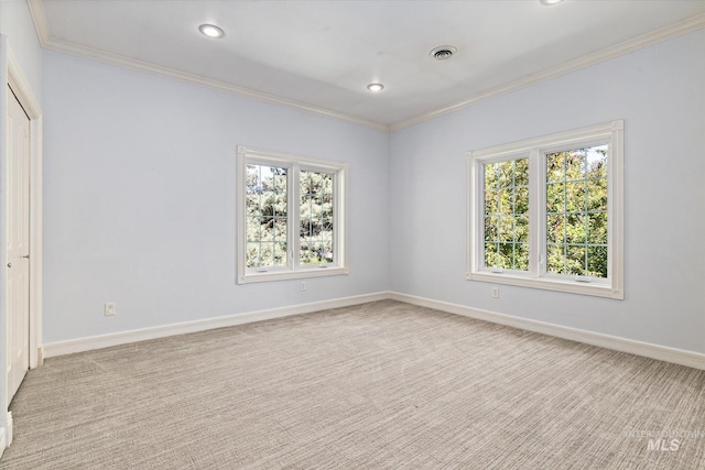 spare room with healthy amount of natural light, carpet flooring, ornamental molding, baseboards, and recessed lighting
