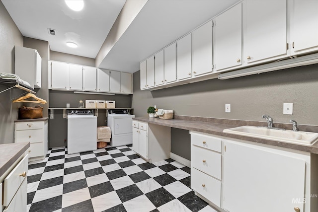 laundry area featuring washing machine and clothes dryer, cabinet space, and dark floors