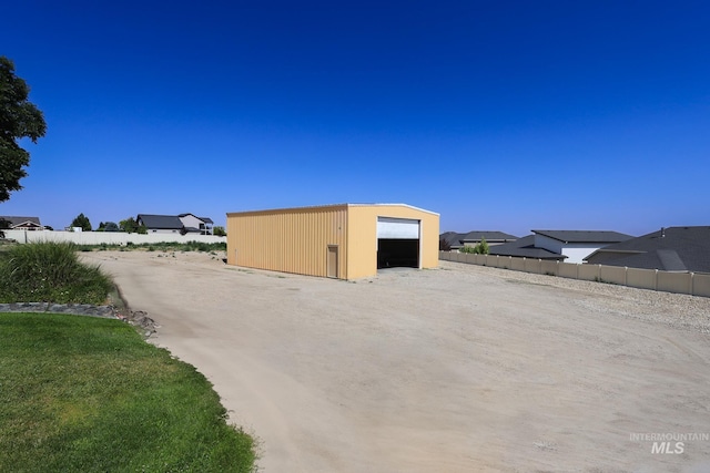 view of outdoor structure featuring a garage and a lawn