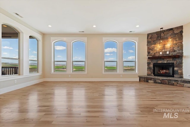 unfurnished living room featuring baseboards, wood finished floors, and visible vents