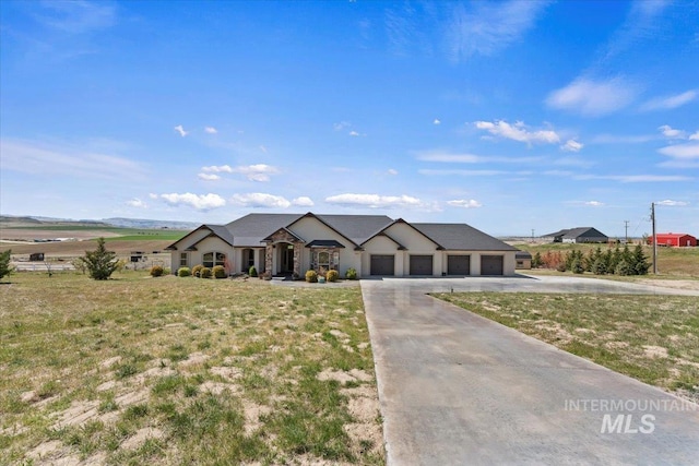 modern farmhouse featuring a garage, stucco siding, a front yard, and concrete driveway