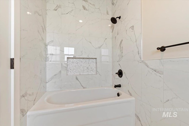 bathroom featuring bathing tub / shower combination and tile walls