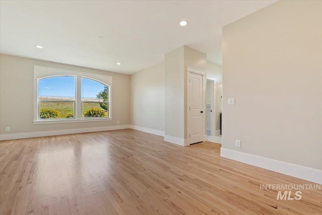 spare room with recessed lighting, light wood finished floors, and baseboards
