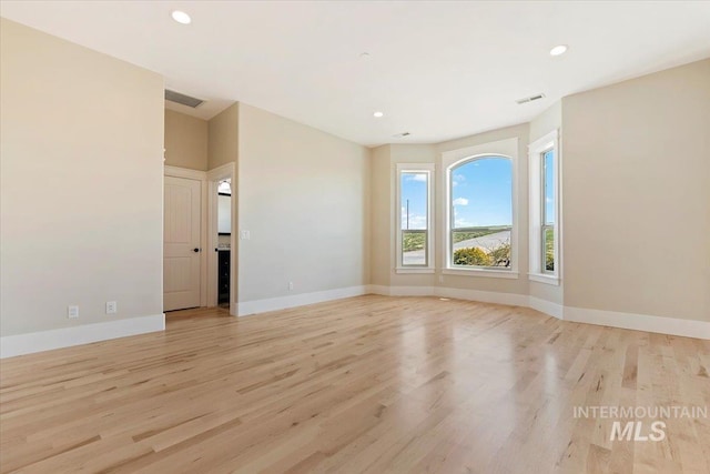 unfurnished room featuring recessed lighting, light wood-type flooring, visible vents, and baseboards