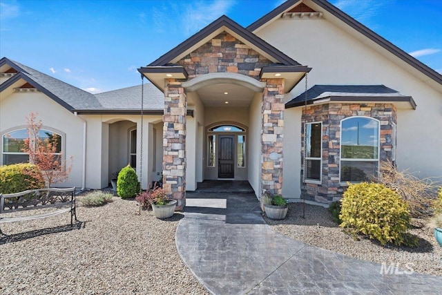 property entrance with stone siding and stucco siding