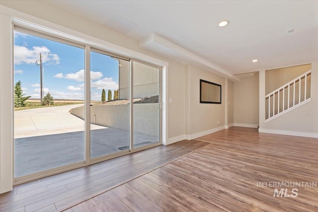 spare room featuring baseboards, wood finished floors, and recessed lighting