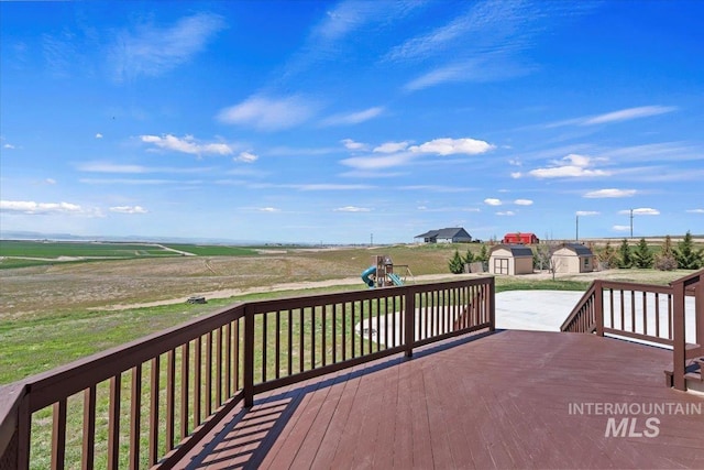 wooden deck with an outdoor structure, a playground, and a storage shed