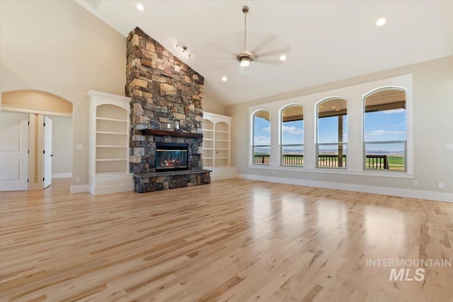 unfurnished living room with baseboards, a healthy amount of sunlight, wood finished floors, and a fireplace