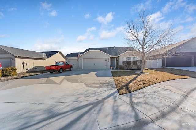 single story home with concrete driveway, fence, an attached garage, and a gate