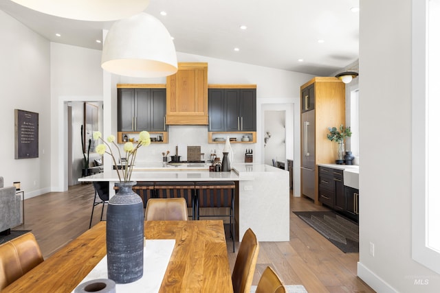 5720 W Little Feather St, Eagle, ID 83616 - kitchen featuring light countertops, wood finished floors, lofted ceiling, a center island with sink, and recessed lighting