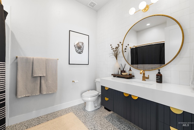 5720 W Little Feather St, Eagle, ID 83616 - bathroom featuring baseboards, vanity, toilet, and decorative backsplash