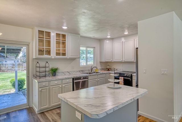 413 S Minnesota Ave, Fruitland, ID 83619 - kitchen featuring stainless steel appliances, white cabinets, light wood-style flooring, light countertops, and glass insert cabinets