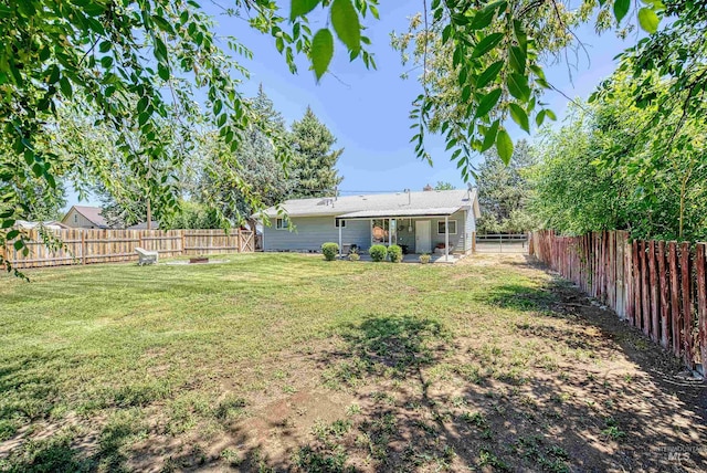 413 S Minnesota Ave, Fruitland, ID 83619 - fenced backyard with a fire pit and a patio area