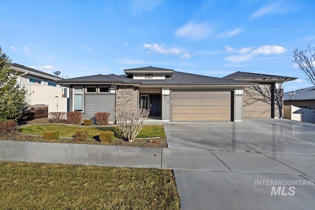 prairie-style house featuring a garage and a front lawn