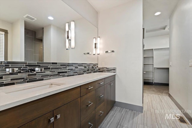 bathroom featuring vanity and tasteful backsplash