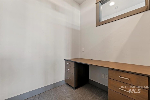 unfurnished office with light colored carpet and built in desk