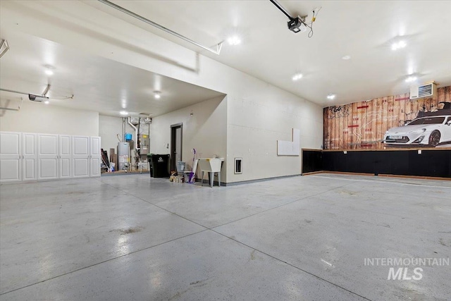 garage featuring sink, gas water heater, and a garage door opener