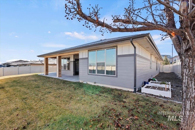 back of house with a patio area and a yard