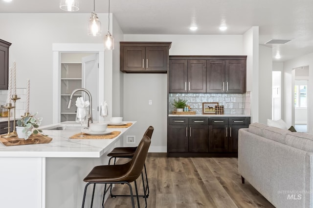 1753 E Grayson, Meridian, ID 83642 - kitchen featuring wood finished floors, dark brown cabinetry, backsplash, a sink, and pendant lighting