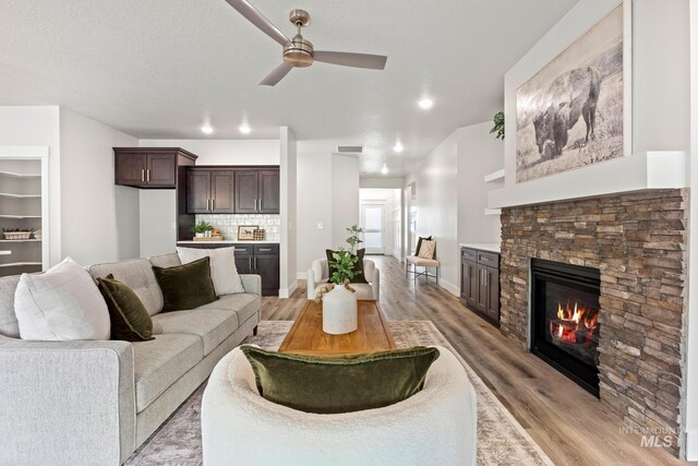 1753 E Grayson, Meridian, ID 83642 - living room with a stone fireplace, a ceiling fan, light wood-style flooring, baseboards, and recessed lighting