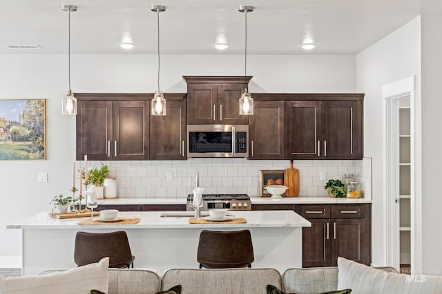 1753 E Grayson, Meridian, ID 83642 - kitchen with stainless steel microwave, tasteful backsplash, dark brown cabinetry, and pendant lighting