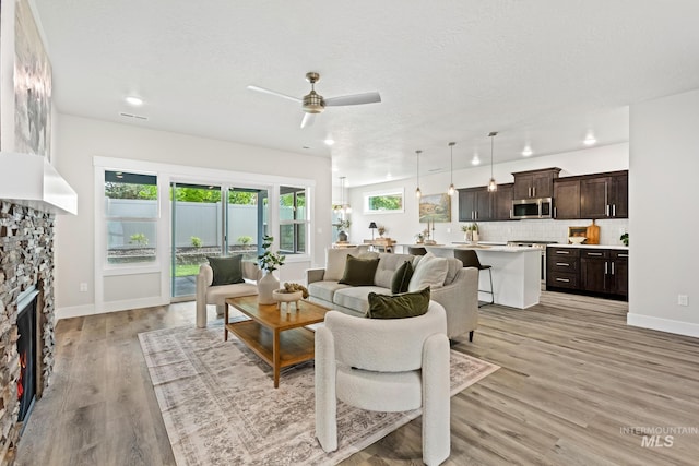 1753 E Grayson, Meridian, ID 83642 - living room featuring a ceiling fan, light wood-style floors, a fireplace, baseboards, and recessed lighting